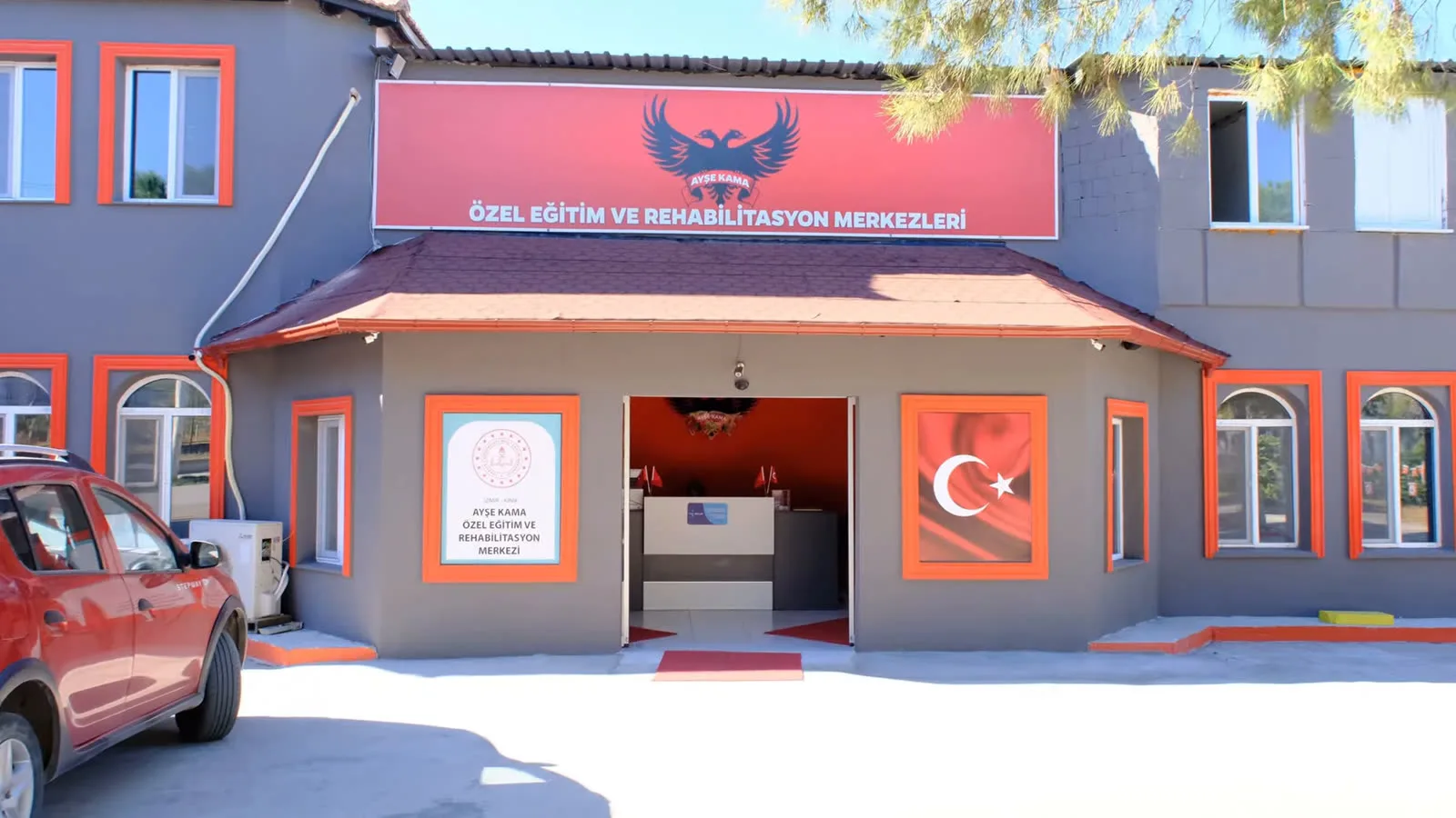 Merkezimizin girişi: kırmızı tabelalı, gri binamız